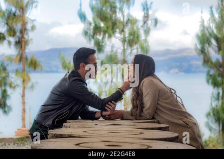 Selective focus shot of cute couple sitting in an outdoor cafe and looking at each other with love Stock Photo
