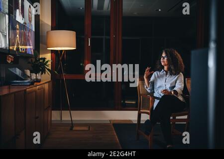 businesswoman leading a confrence call  with team late night. Multiracial business people having a video call. Stock Photo