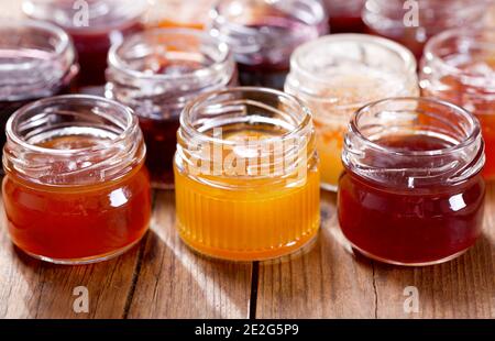 various jars of fruit jam on wooden table Stock Photo