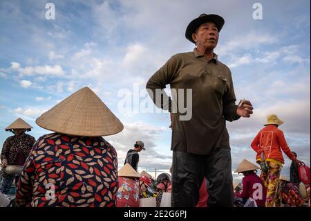 Men and women working at a fish Market on the beach, Mui Ne, Vietnam Stock Photo