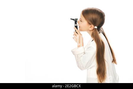 Positive girl in white medical uniform holding ophthalmoscope, isolated on white, empty space Stock Photo