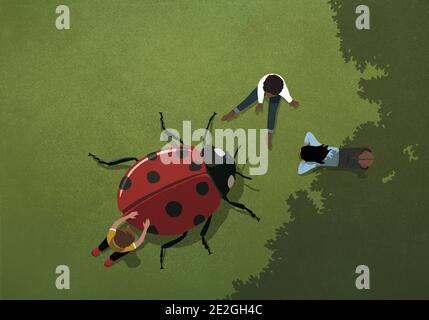 Kids playing with large ladybug in grass Stock Photo