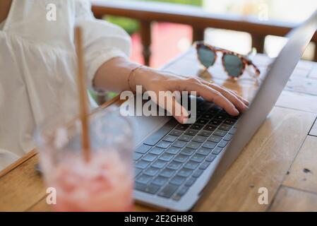 Close up woman using laptop at outdoor cafe table Stock Photo