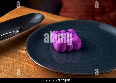 French Mousse Mini Desserts with Purple Velvet Cover on the table, serving in a restaurant, menu food concept. Stock Photo