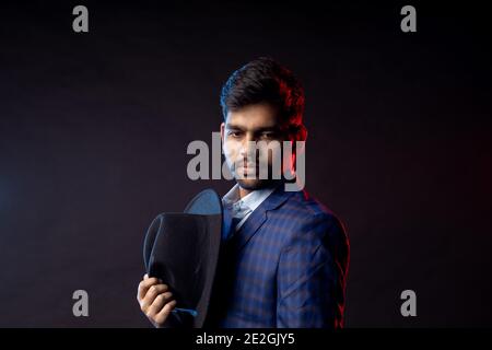 Closeup portrait of young handsome confident serious bearded Indian man, businessman with stylish hairstyle, wearing shirt, checkered suit standing ag Stock Photo