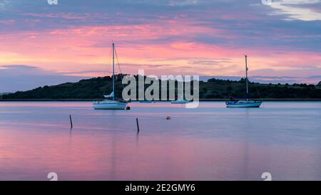 Boats on the Swale estuary in Kent at sunset. Taken from Harty Ferry, Faversham. Stock Photo