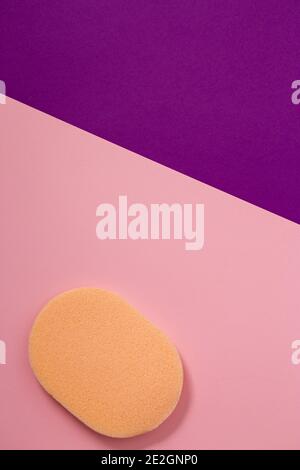 orange cosmetic sponge for makeup on pink background Stock Photo