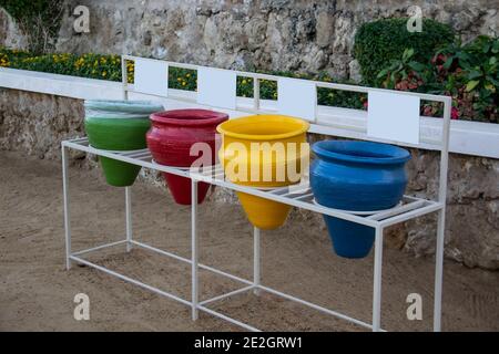 Colorful Waste sorting pots. Different colored bins for collection garbage.  Blue,  green, red, yellow ceramic vases for garbage Stock Photo