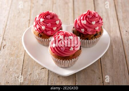 Cupcakes decorated with sugar hearts for Valentine's Day on wooden table Stock Photo