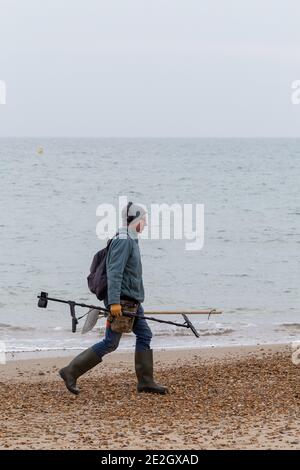 Man with metal detector walks along Bournemouth beach in the winter 30 November 2020 Neil Turner Stock Photo