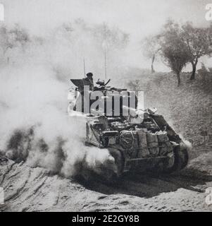 Archival photo of Allied invasion of Sicily (Operation Husky). In a cloud of dust, a 'sherman' tank with a heavy load moves towards Rimini. Stock Photo