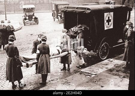 A red cross patrol carries a patient into an ambulance during the Spanish flu epidemic in St. Louis, Missouri, October 1918.