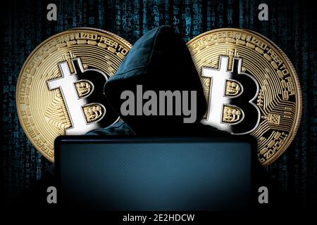 hacker with bitcoins behind notebook laptop in front of blue source binary code background internet cyber hack attack crypto currency blockchain compu Stock Photo