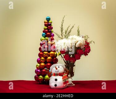 Christmas scene with flowers snowman and christmas tree made of shiny decorative balls ornaments Stock Photo