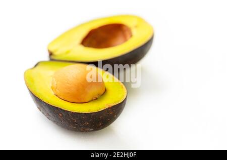 Close up two cut half fresh avocado with its seed on white background with natural light, healthy fruit avocado, avocado which be grown in Thailand. Stock Photo