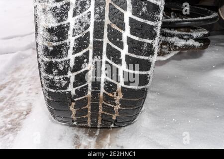 Car wheel close-up on the snow with a tread, wheel tread on the snow, a trace of a worn wheel on the snow Stock Photo