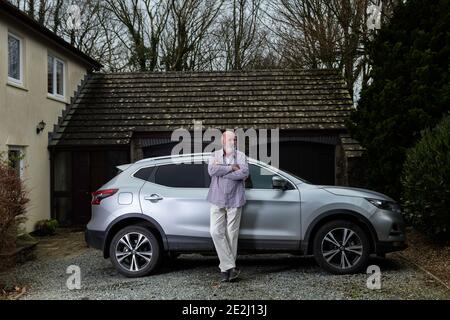 Casually dressed senior man with his silver car. Stock Photo