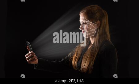 Young Caucasian businesswoman using biometric technology in her phone. Stock Photo