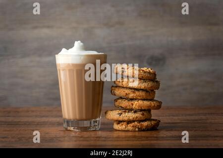 Coffee Latte in a glass with a stack of cookies on a wooden table Stock Photo