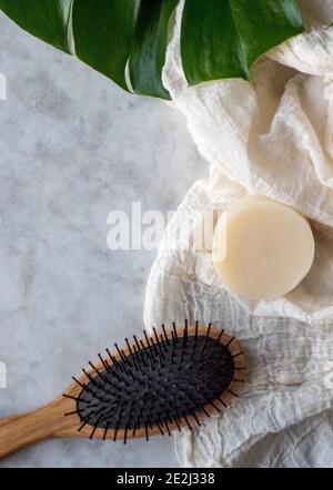 Solid Shampoo bar with Argan Oil isolated on a marble board and a hair brush Stock Photo