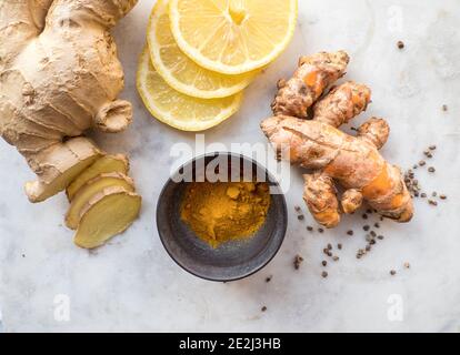 Naturally healthy and immune system boosting Turmeric spice powder, lemon slices and ginger roots Stock Photo