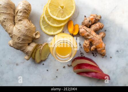 Healthy immune system boosting orange, apple and lemon ginger shot in a small glas bottle Stock Photo