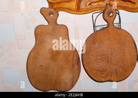 Wooden cutting boards in the shape of an apple and a pear hang on the wall Stock Photo