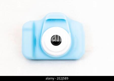 A blue toy childs digital camera with white background using selective focus on the lens. Stock Photo