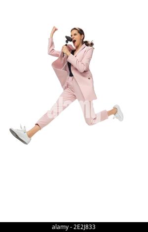 Rockstar. Happy young woman dancing in casual clothes or suit, remaking legendary moves and dances of celebrity from culture history. Isolated. Action, motion, fame concept. Creative occupation. Stock Photo