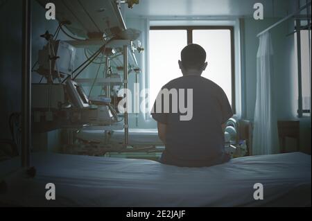 Doctor siiting on the empty bed in the hospital. Stock Photo