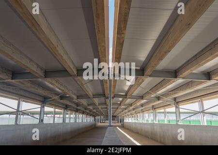 Close-up view of the connection of metal and wooden beams. Steel roof frame under construction. The interior of a big industrial building or factory w Stock Photo