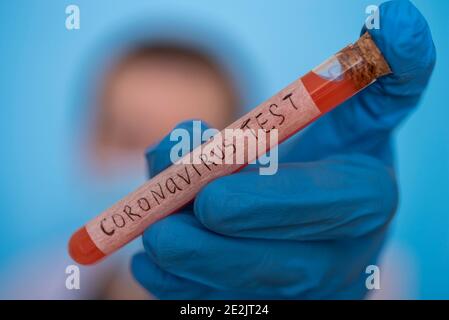 Nurse wearing respirator mask holding a positive blood test result for the new rapidly spreading Coronavirus, originating in Wuhan, China. The concept Stock Photo