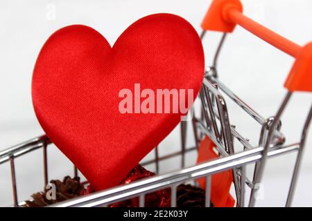 Red heart in shopping cart over white Stock Photo