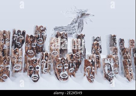 Perm Krai, Russia - January 02, 2021: snow-covered wooden art object - group of idols depicting anthropomorphic figures and elk Stock Photo