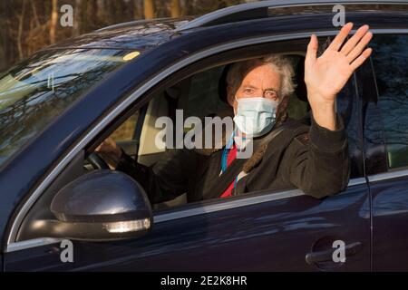 Elder man with facemask in car saying hi Stock Photo