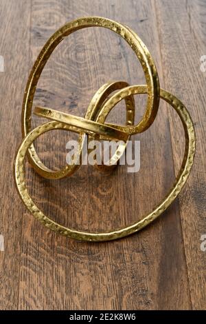 Gold metal torus infinity shape on dark hickory wood Stock Photo