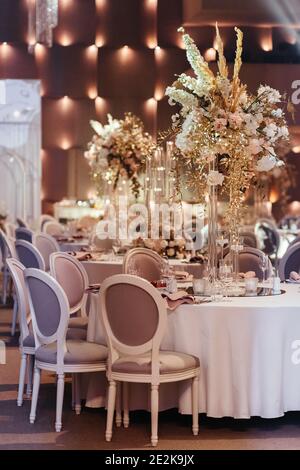 View on the wedding dining table decorated with flowers and candles. Place for guest at the wedding. Wedding table setting. Wedding banquet Stock Photo