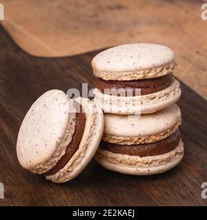 Coffee in glass cup and chocolate macarons on wooden background. Cozy autumn composition - Image Stock Photo