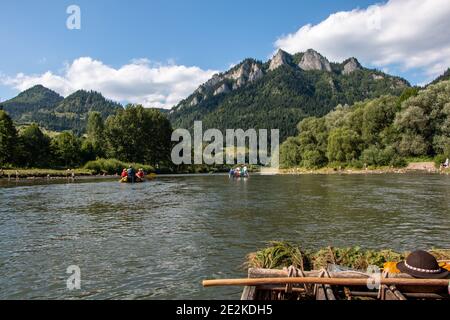 Tourists rafting and punting on the Dunajec River on the border between Poland and Slovakia with Trzy Korony Mountain in Pieniny National Park Stock Photo