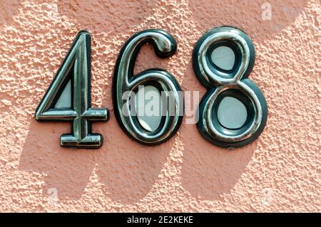 House number plate 468 on a wall. Street number. Address number. Stock Photo