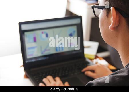 Young man using laptop and working from home Stock Photo