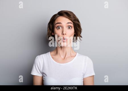 Portrait of young shocked amazed girl woman female look in camera hear unbelievable news isolated on grey color background Stock Photo