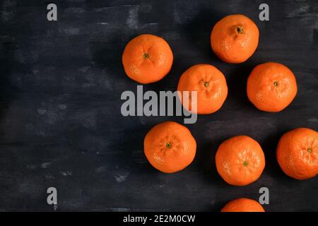 Whole mandarin fruits on dark background Stock Photo