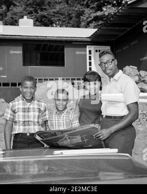 1960s AFRICAN AMERICAN FAMILY STANDING BEFORE THEIR NEW HOME UNDER CONSTRUCTION FATHER HOLDING PLANS SMILING LOOKING AT CAMERA - j12522 HAR001 HARS UNDER FOUR MOM CLOTHING NOSTALGIC 4 COMMUNITY SUBURBAN MOTHERS OLD TIME FUTURE NOSTALGIA BROTHER OLD FASHION 1 JUVENILE STYLE SECURITY DESIGN SONS PLEASED FAMILIES JOY LIFESTYLE SATISFACTION ARCHITECTURE FEMALES HOUSES MARRIED BROTHERS SPOUSE HUSBANDS HEALTHINESS HOME LIFE PLANS COPY SPACE FRIENDSHIP HALF-LENGTH LADIES PERSONS RESIDENTIAL MALES BUILDINGS SIBLINGS CONFIDENCE FATHERS B&W PARTNER EYE CONTACT FREEDOM GOALS SUCCESS BEFORE DREAMS Stock Photo