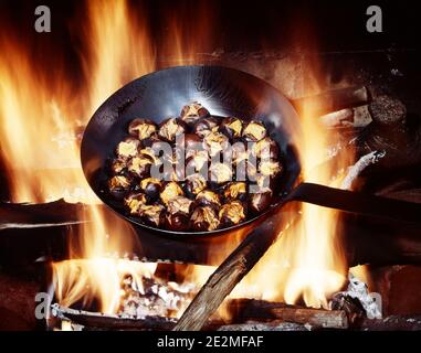 1980s CHESTNUTS ROASTING IN IRON SKILLET ON AN OPEN FIRE TRADITIONAL WINTER CHRISTMAS FARE  - kf17643 DAS001 HARS NOURISH SNACK FOOD SONG HOLIDAYS DECEMBER FRYING HOLIDAY CHRISTMAS NIGHT BEFORE CHRISTMAS STILL LIFE WARMTH NOURISHMENT CHESTNUTS SKILLET FIREPLACES FRYING PAN NUT OPEN FIRE ROASTING 25TH CHRISTMAS EVE DECEMBER 25TH OLD FASHIONED Stock Photo