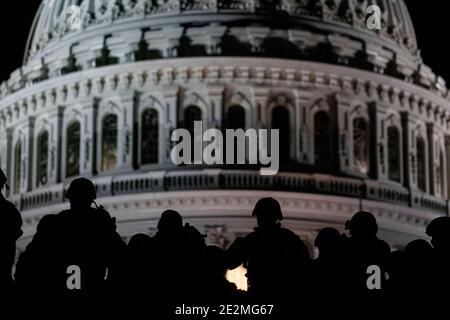 Washington, United States. 13th Jan, 2021. U.S. soldiers and airmen with the National Guard are silhouetted against the Capitol dome as they secure the area for the 59th Presidential Inauguration January 13, 2021 in Washington, DC More than 10,000 national guard troops have been deployed to provide security following the insurrection by Pro-Trump rioters. Credit: Planetpix/Alamy Live News Stock Photo