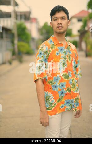 Adult guy in a Hawaiian shirt, walking down the street Stock Photo