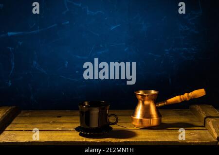 Copper coffee pot and black ceramic mug. Turkish coffee. Front view. Stock Photo