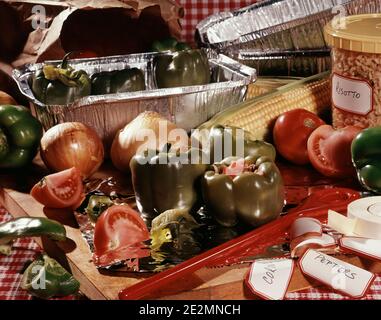 1980s VEGETABLE INGREDIENTS NECESSARY TO MAKE STUFFED GREEN BELL PEPPERS TOMATOES ONIONS CORN ARRANGED ON CHOPPING BOARD - kf19164 DAS001 HARS ONIONS Stock Photo