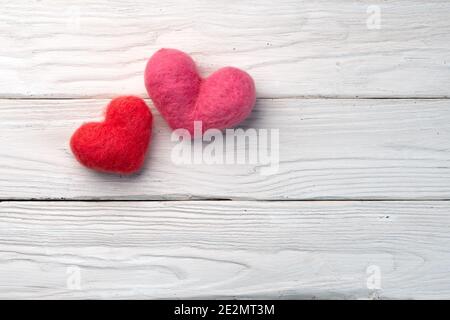 Two woolen handmade hearts on the white wooden boards Stock Photo